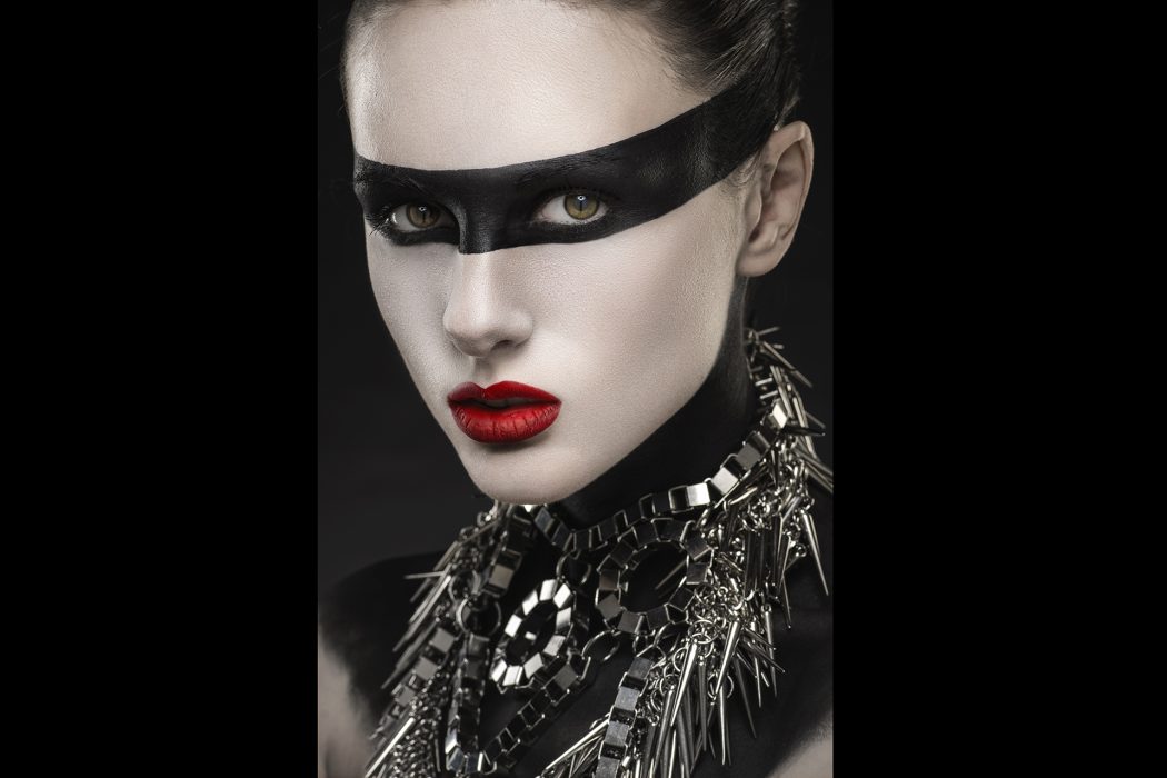 Woman with face-art and silver necklace