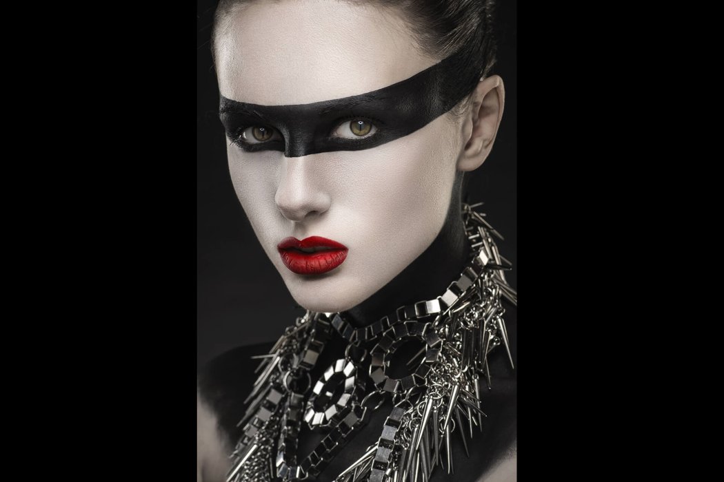 Woman with face-art and silver necklace