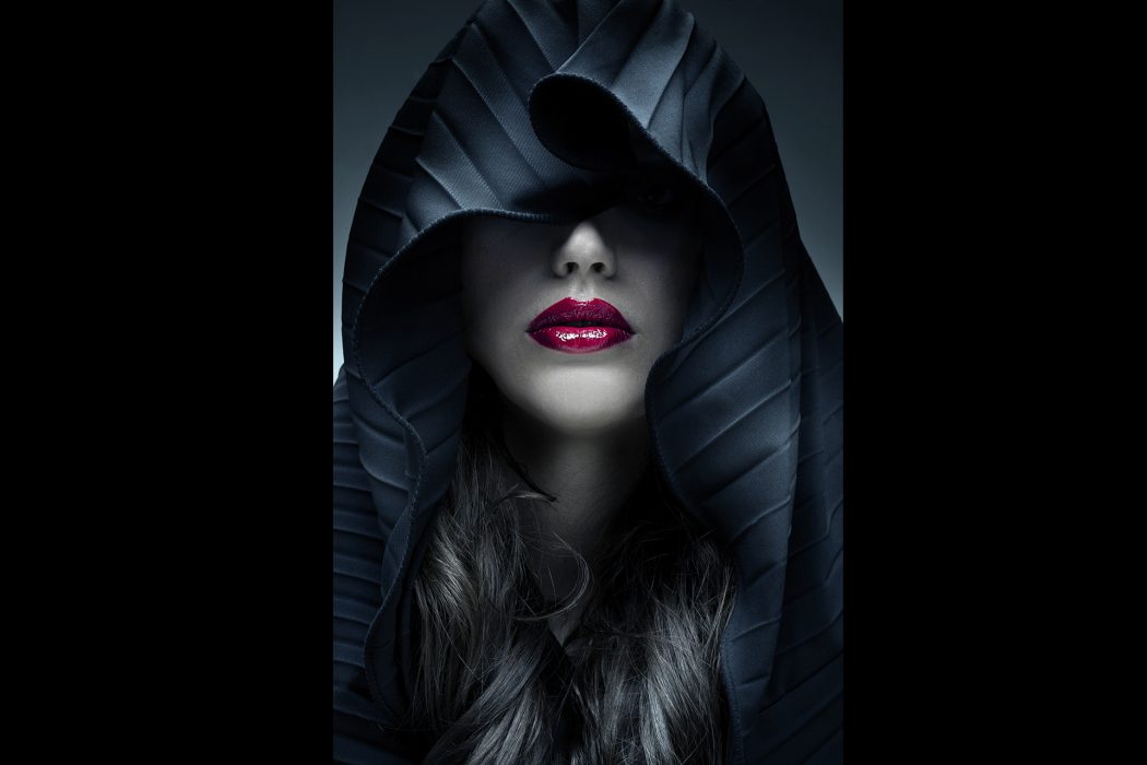 Portrait of mysterious woman in dark hood